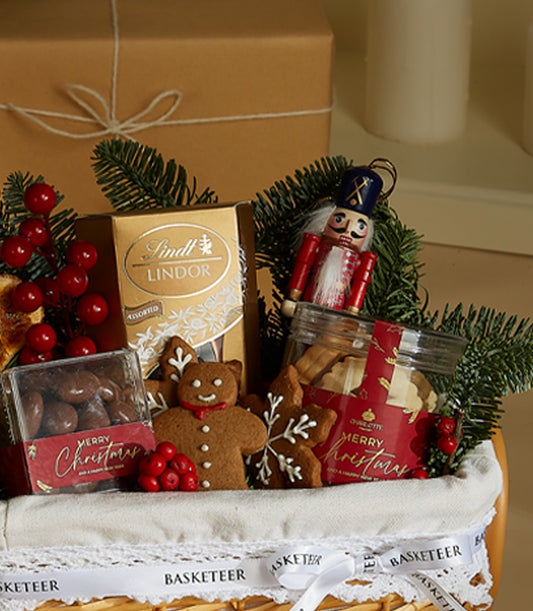 Festive Cheer mini gift basket with Lindt chocolates, gingerbread cookies, and holiday treats in woven basket with red
