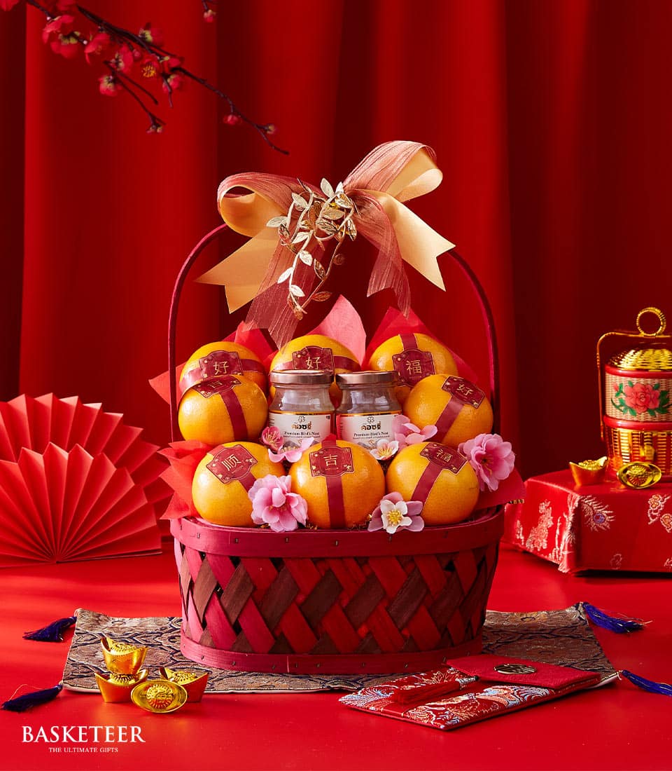 Red woven basket with mandarin oranges, gold-trimmed jars, and traditional Chinese New Year symbols on red background