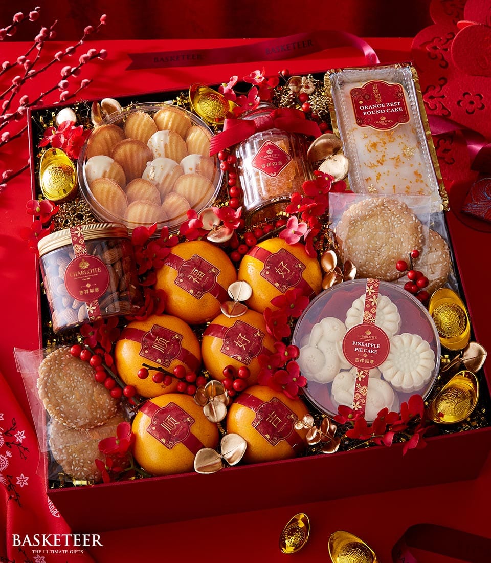 Luxury red and gold Chinese New Year gift basket with mandarin oranges, gourmet cakes, cookies, and festive confections