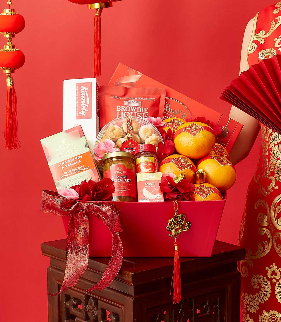 Red luxury gift basket with green tea, gourmet treats, fresh oranges, and gold dragon charm for Lunar New Year