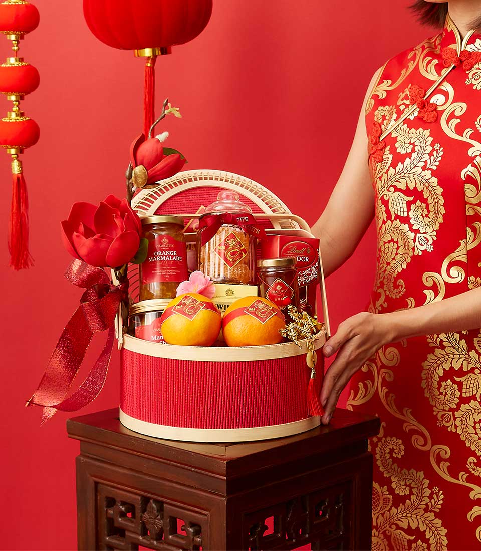 Red ribbed gift basket with mandarins, marmalade, and Lindt chocolates for Chinese New Year celebrations