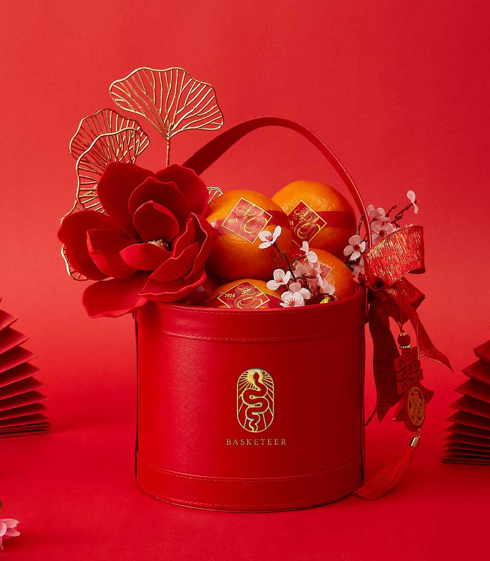 Lunar Citrus Elegance red leather gift box with mandarin oranges, gold dragon stickers, and Chinese New Year decorations