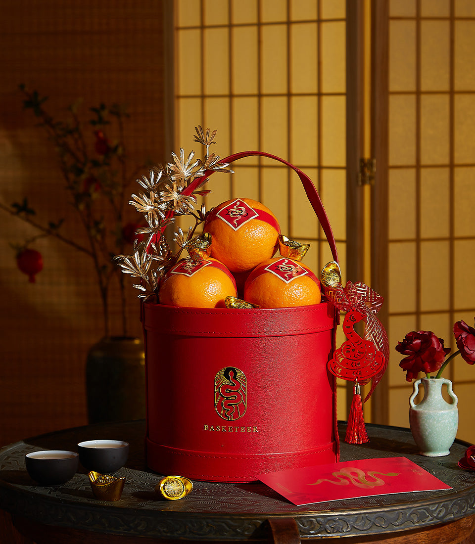 Basketeer luxury gift box for prosperity: Mandarin oranges with gold accents in a vibrant red container. Premium hamper delivery Thailand.