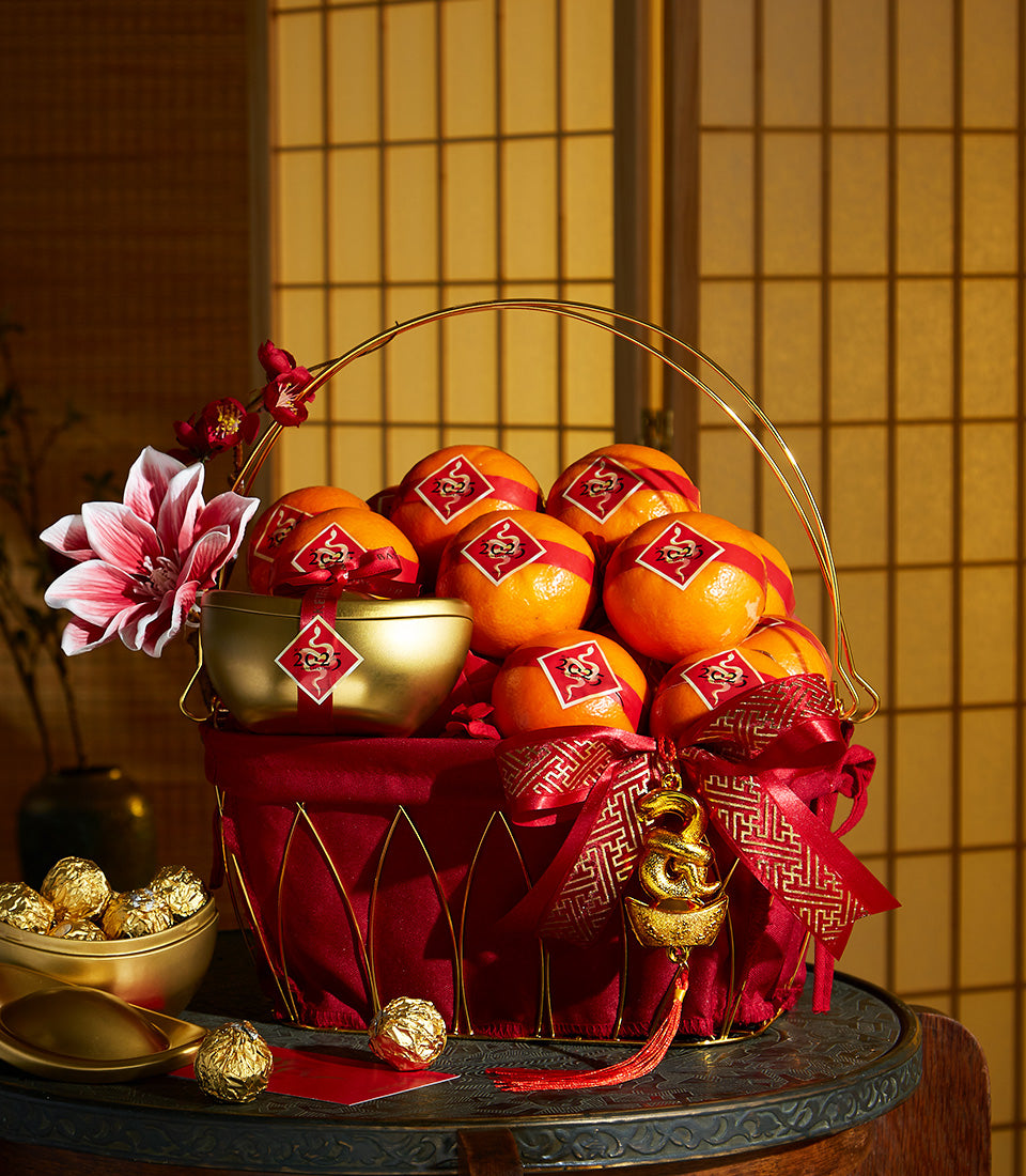 Basketeer luxury gift basket for Chinese New Year. Oranges, chocolates, and gold accents abound. Premium hamper delivery Bangkok, perfect corporate gift.
