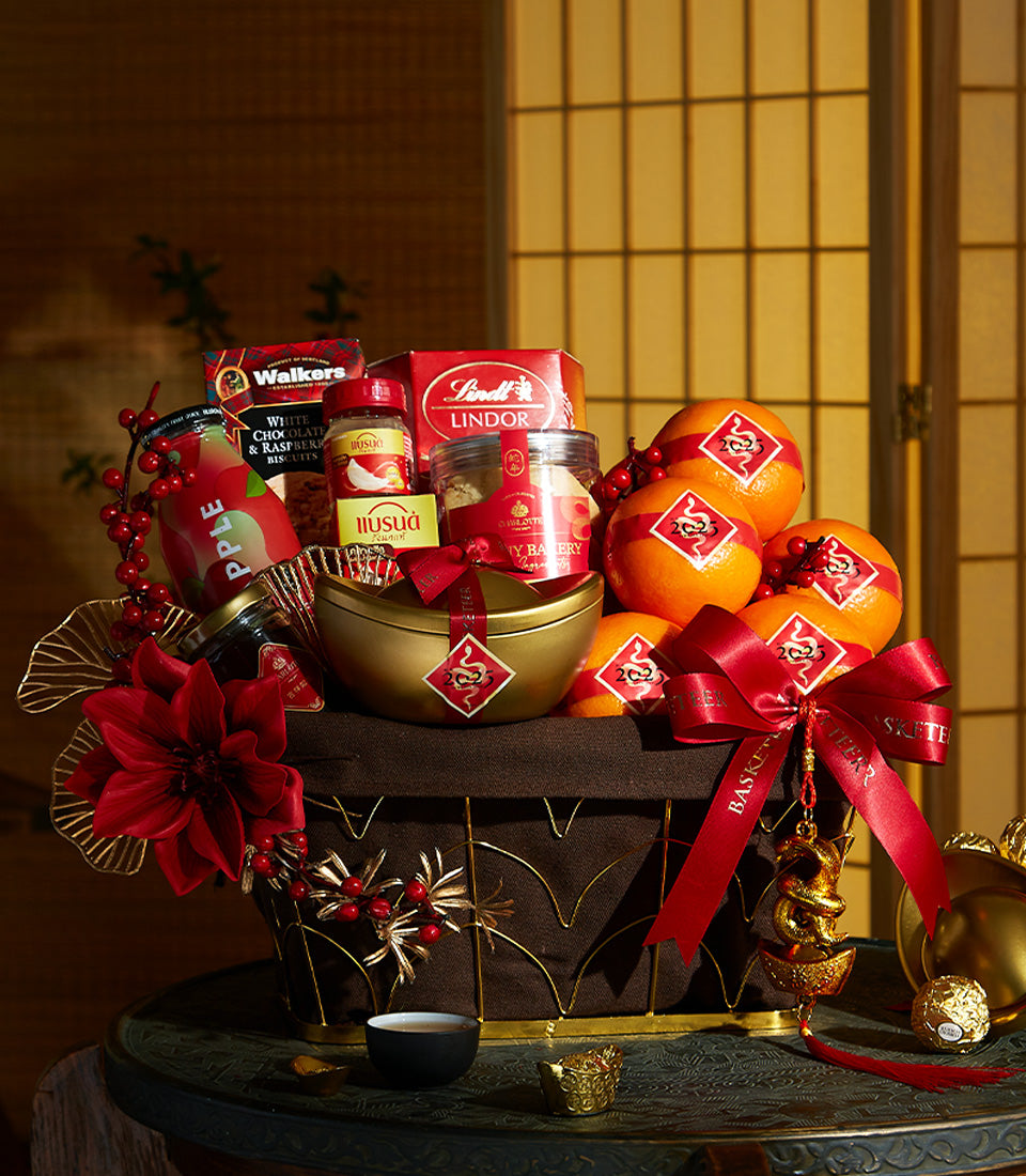 Luxury Chinese New Year gift basket with gourmet treats, gold ingots, and red silk ribbons