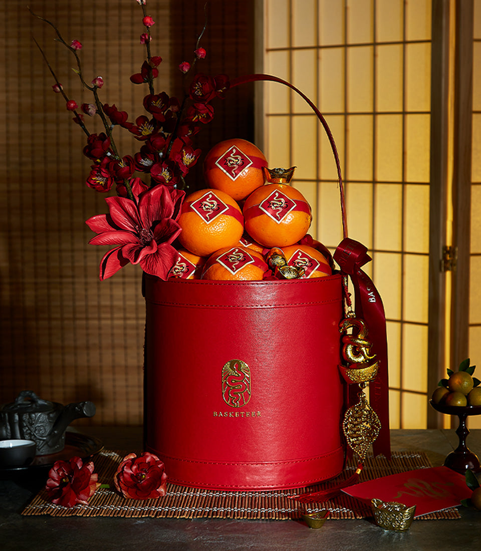 Luxury red leather gift box with lucky tangerines and gold accents for Chinese New Year celebrations