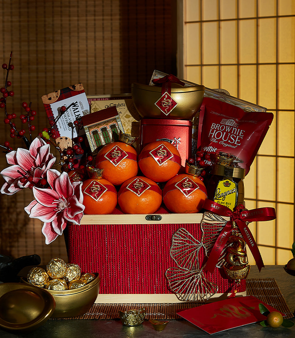 Red and gold Chinese New Year hamper with fresh oranges, brownies, honey, shortbread, and festive flowers in natural wood box