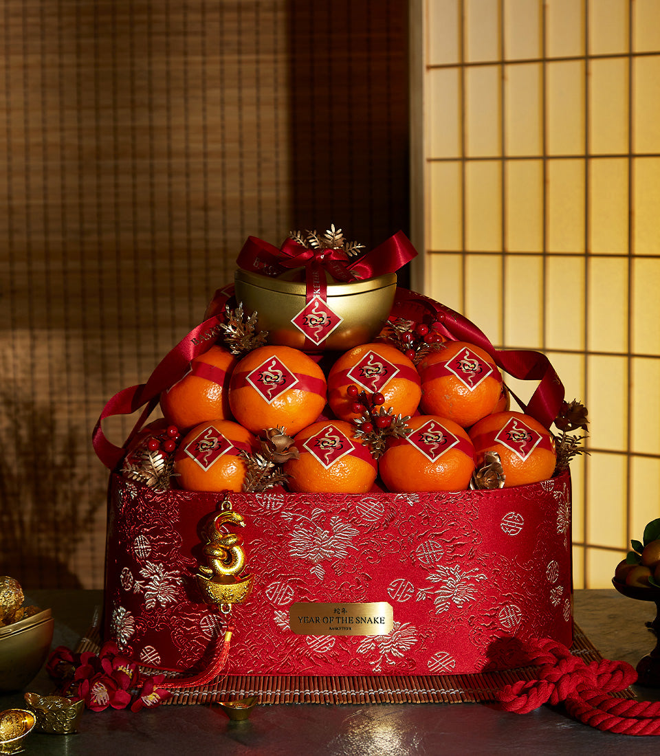 Festive red and gold Chinese New Year hamper with fresh mandarins, berries, and golden container adorned with Year of the