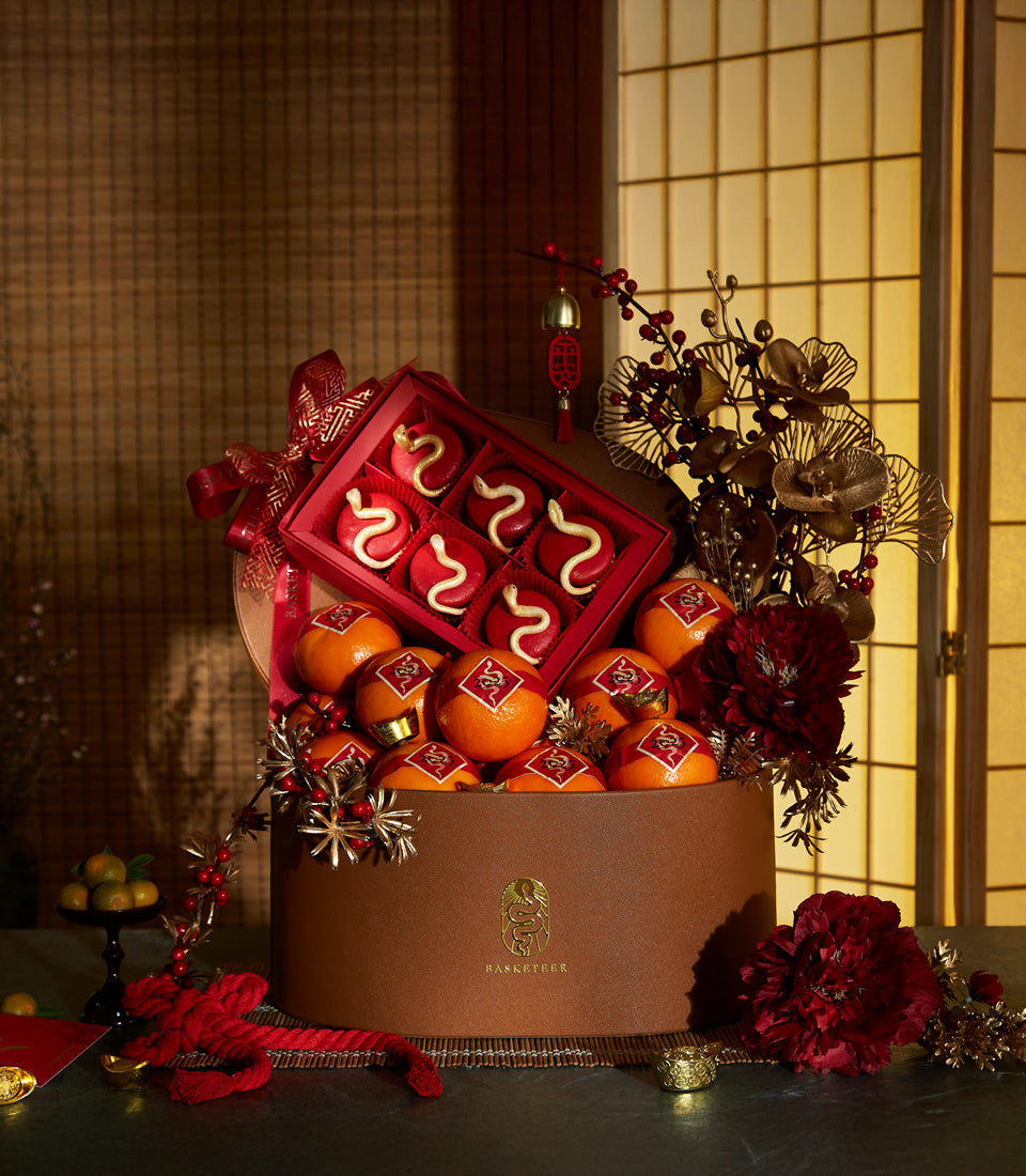 Luxury Fortune Snake gift box with mandarins, confectionery, and gold festive accents for Chinese New Year