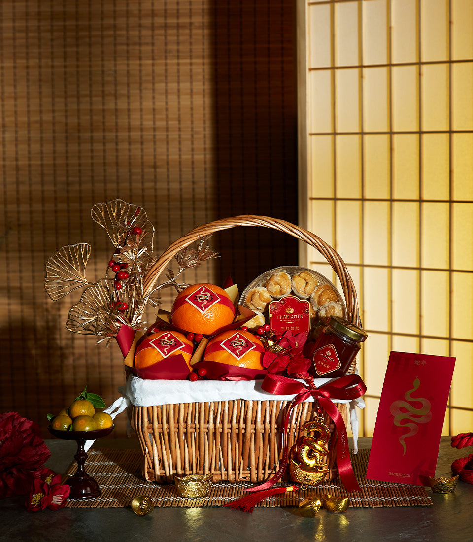 Festive Harmony Mandarin basket with red-wrapped oranges, pastries, and gold snake ornaments for Chinese New Year