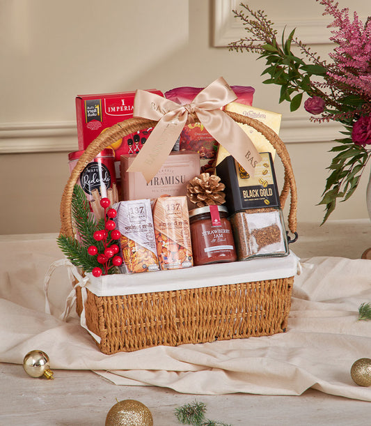 Woven wicker gift basket with gourmet coffee, biscuits, chocolate, and jam tied with champagne ribbon for New Year gifting