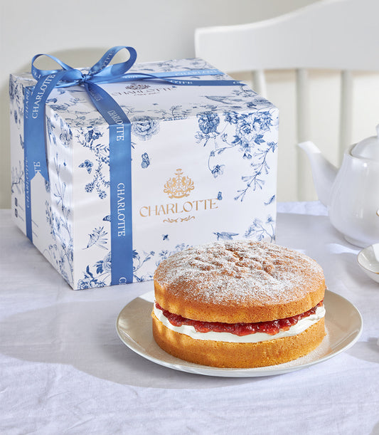 Classic Victoria Sponge cake with jam and cream, presented in Charlotte Bakery gift box with blue floral wrap