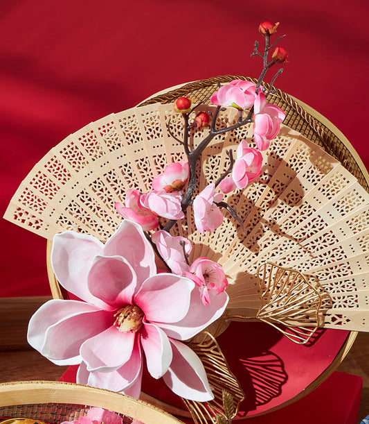 Mandarin oranges and pastry gift set with carved wooden fan and pink flowers for Chinese New Year