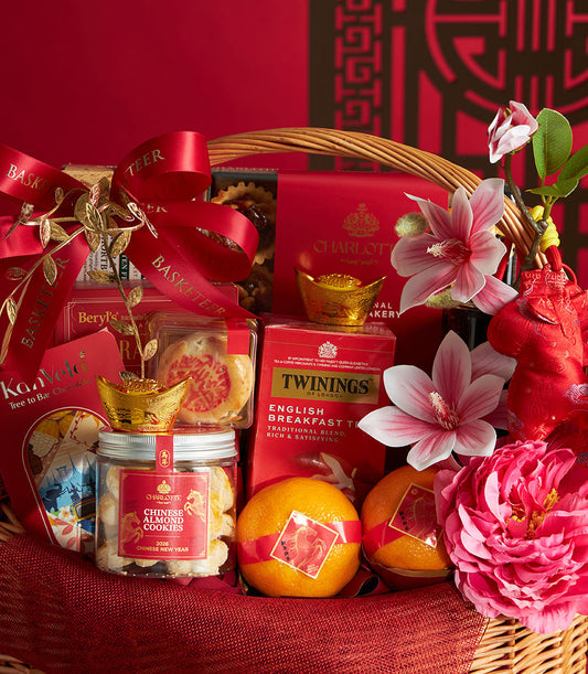 Red and gold Chinese New Year gift basket with mandarin oranges, almond cookies, English breakfast tea, and festive treats