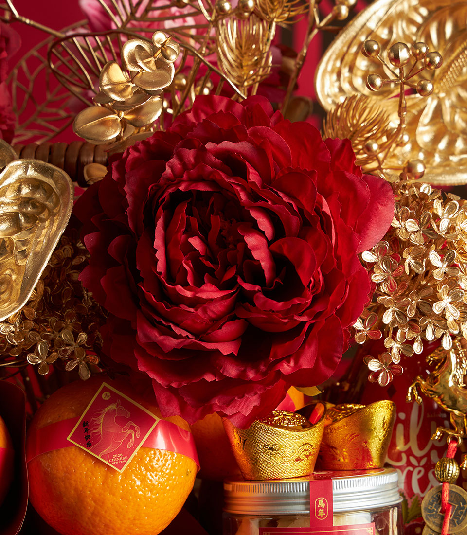 Mandarin oranges, cookies, and gold sycee in festive red and gold Chinese New Year gift basket