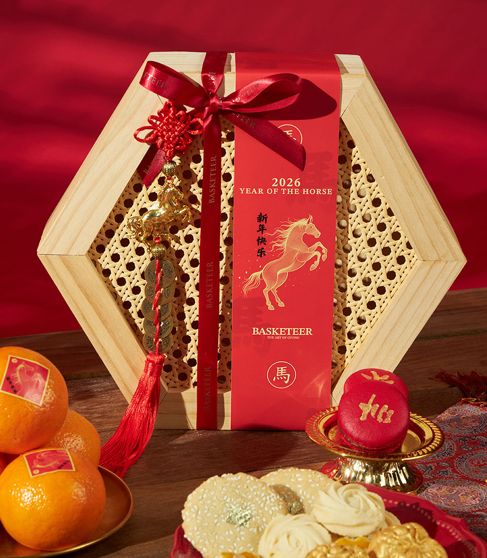 Chinese New Year gift box with Charlotte Bakery cookies, mandarins, and lucky charms in red and gold hexagonal packaging