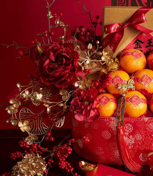 Festive Chinese New Year mandarin orange and pastry gift basket with red peonies, gold accents, and lucky charms on vibrant