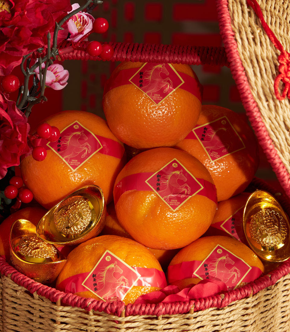 Chinese New Year mandarin orange basket with gold ingots and red artificial flowers in woven wicker