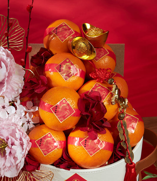 Festive Chinese New Year mandarin orange gift bucket with red ribbons, gold ingots, and lucky charms from Basketeer