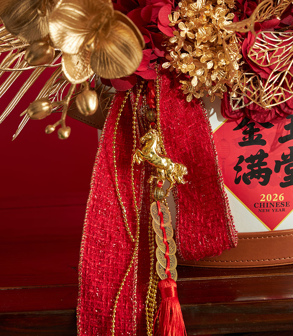 Basketeer premium hamper for Chinese New Year. Gold floral arrangement with red ribbon, horse charm and lucky coins. Perfect corporate gift Bangkok.
