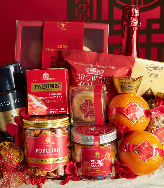 Red and gold Chinese New Year gift hamper with mandarin oranges, tea, chocolates, and gourmet treats