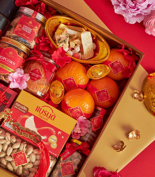 Premium Chinese New Year gift box with mandarin oranges, almond cookies, and traditional candies in red and gold