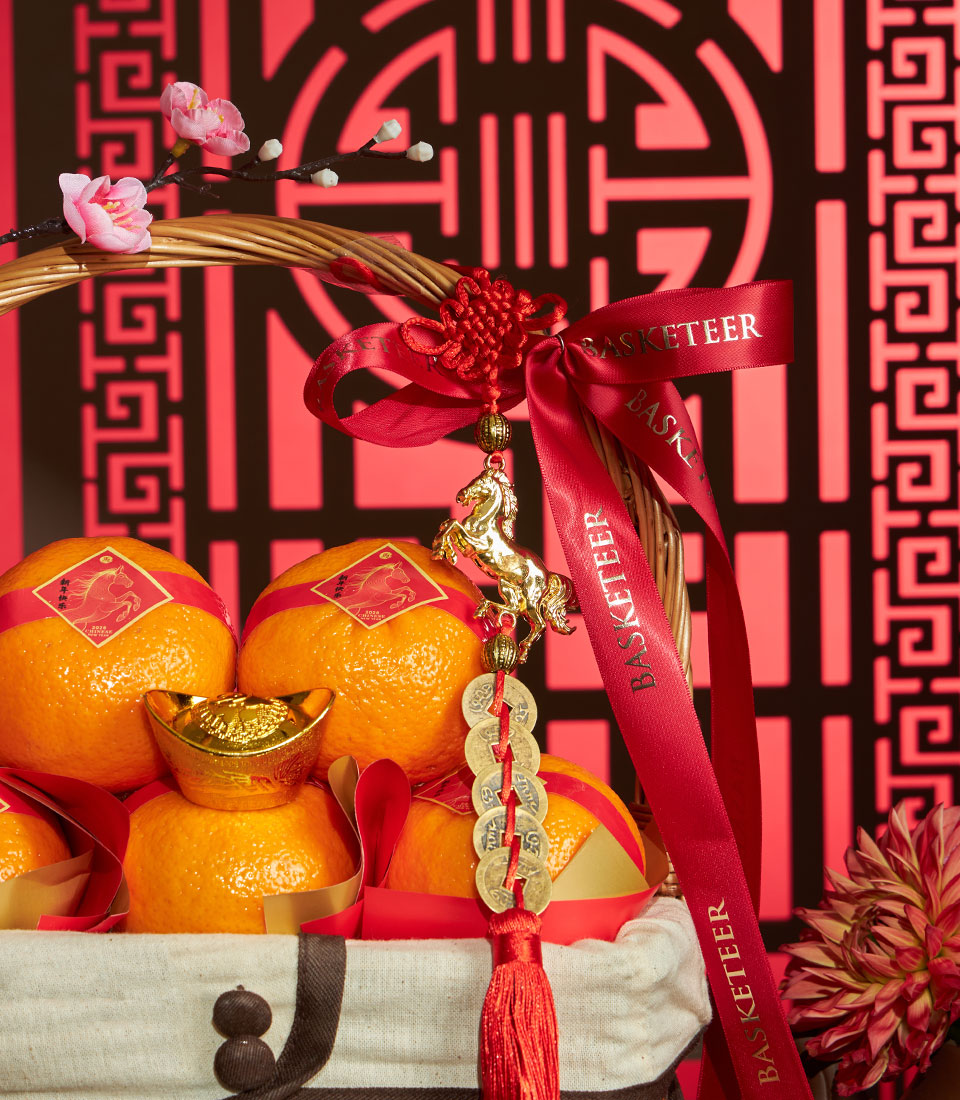 Luxury mandarin orange gift basket with red silk ribbons, gold horse charm, and cherry blossoms for Chinese New Year