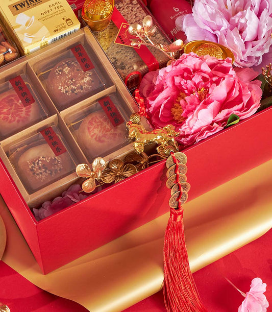 Red gift box with Chinese pastries, Earl Grey tea, BoostBerry drink, and pink peonies, gold accents and lucky coins for