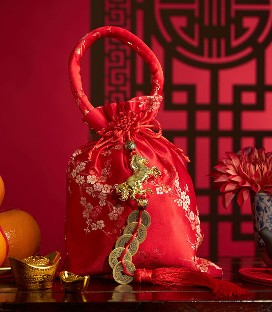 Red satin gift pouch with mandarin oranges, gold ingots, and Chinese coins for Lunar New Year celebration