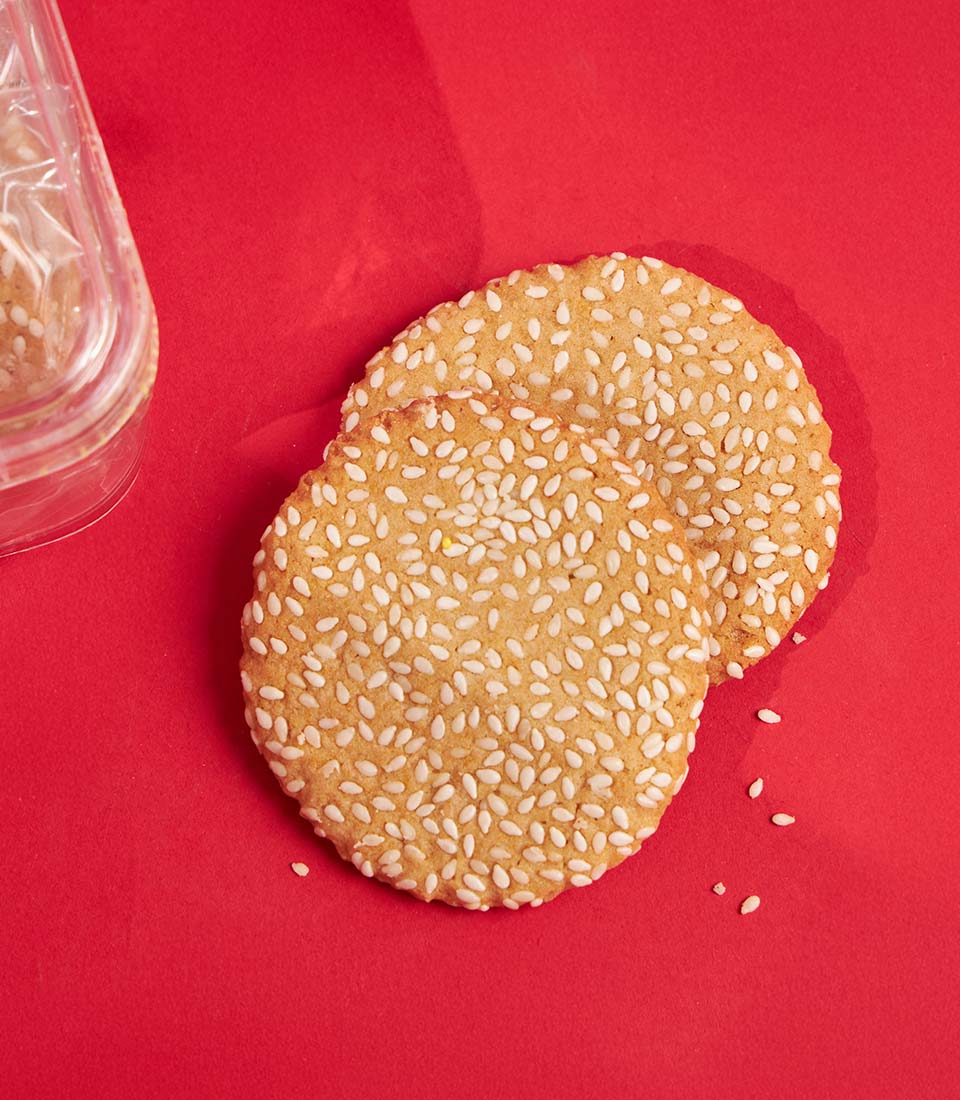 Honey sesame seed cookies with white sesame coating on red background, Charlotte Bakery gift for Chinese New Year