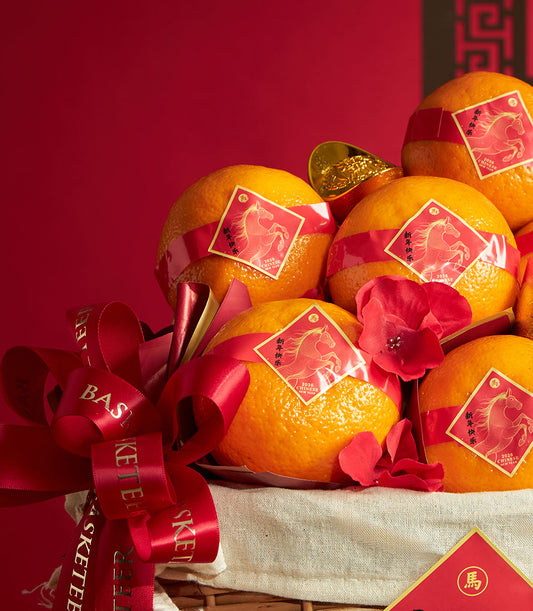 Festive mandarin orange basket with red ribbons and gold ingot charms, classic woven design for Chinese New Year gifting