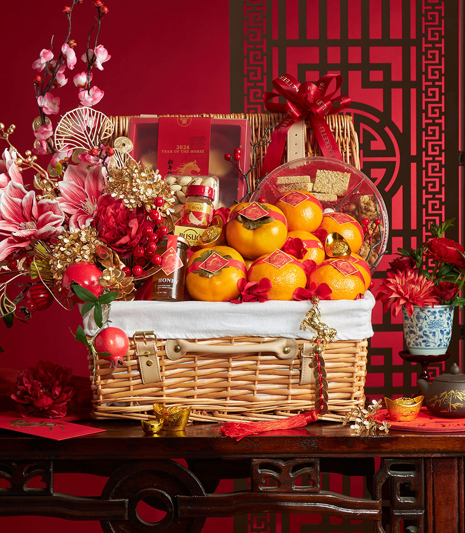 Festive wicker fruit basket with tangerines, persimmons, honey, and gourmet treats for Chinese New Year celebration