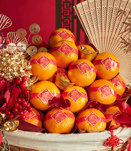 Festive mandarin orange gift basket with bamboo fan, golden ingots, and red ribbons for Chinese New Year celebrations