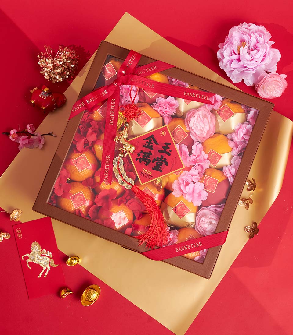 Festive Chinese New Year premium mandarin orange gift box with golden pastries and red floral arrangement, red ribbon, and