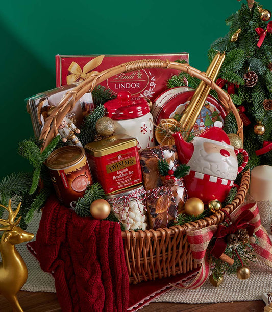 Luxury Christmas gift basket with English breakfast tea, Lindor chocolates, fruitcake, and festive ceramic pieces in woven