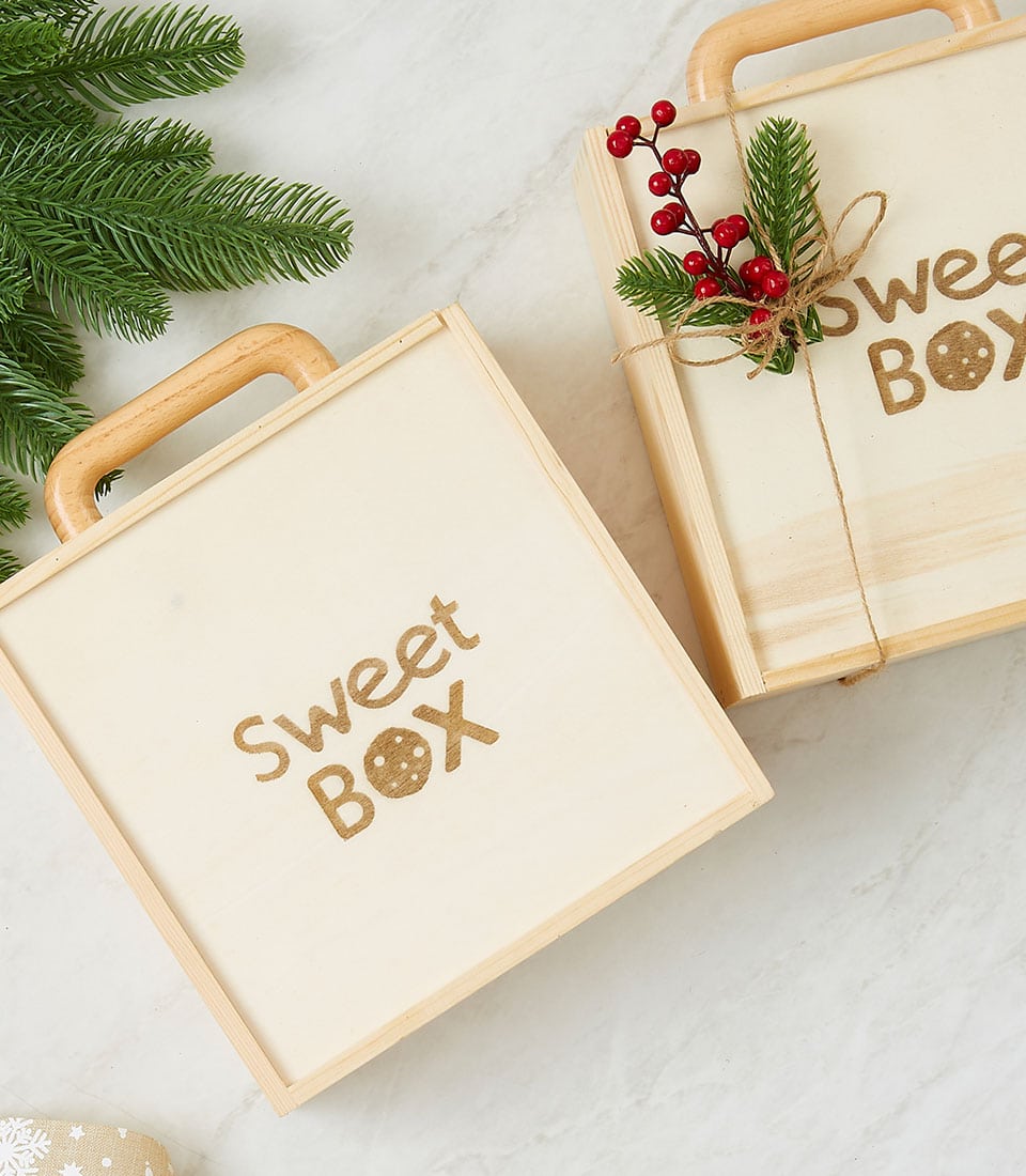 Rustic wooden suitcase gift boxes with cookie details, filled with artisan brownies and cookies for birthday celebrations