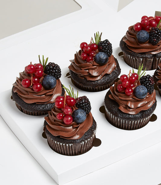 Six chocolate cupcakes with rich cocoa frosting, fresh berries and rosemary sprigs in white gift box