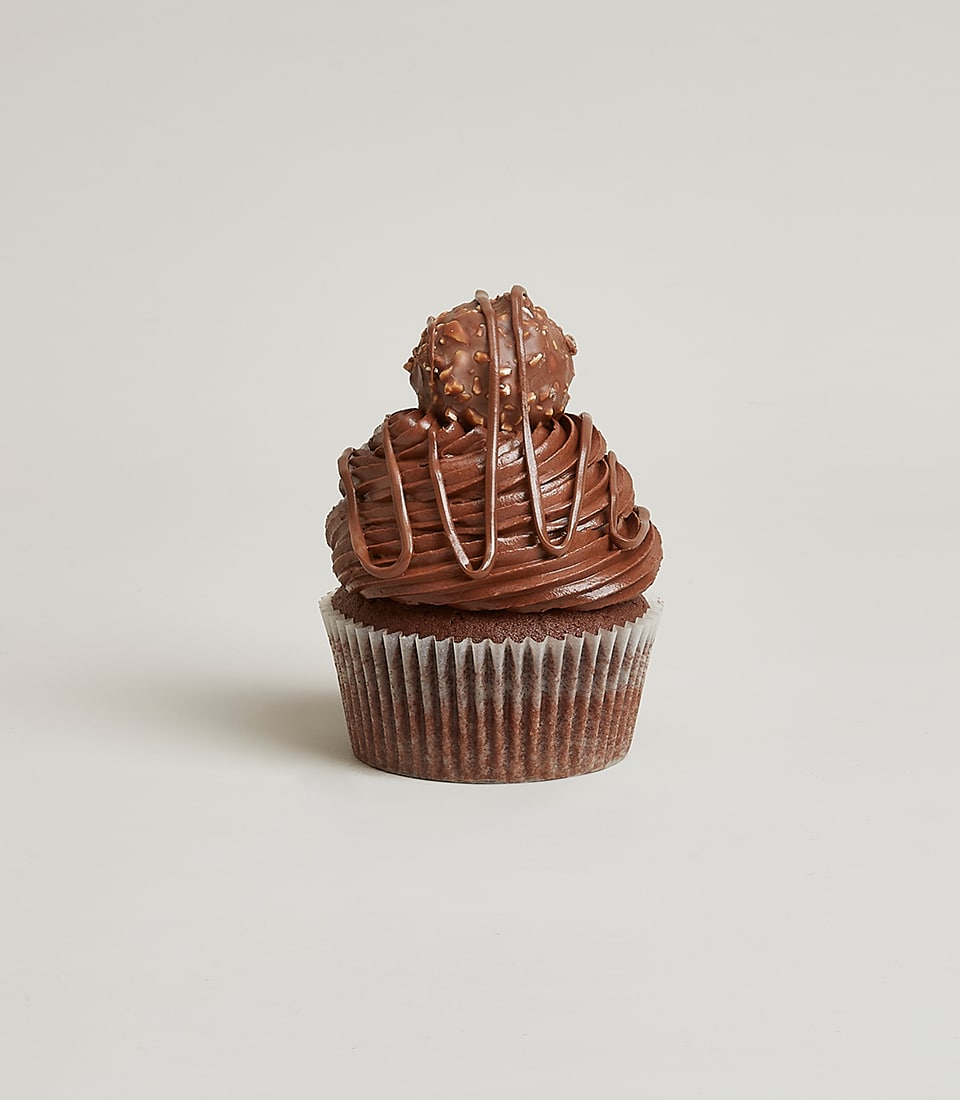 Chocolate cupcake with dark frosting and hazelnut candy topper, artisan bakery gift