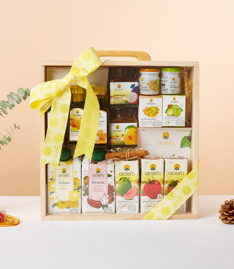 Premium wooden crate with Doi Kham preserves, honey, dried fruit and juice cartons tied with yellow daisy ribbon