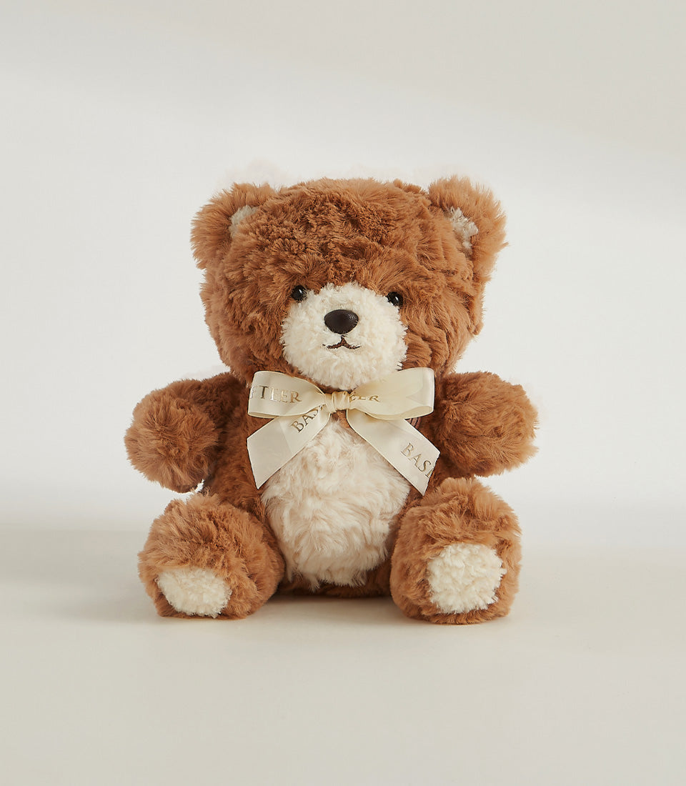 Brown plush teddy bear with cream ribbon bow, soft companion for luxury gift hampers