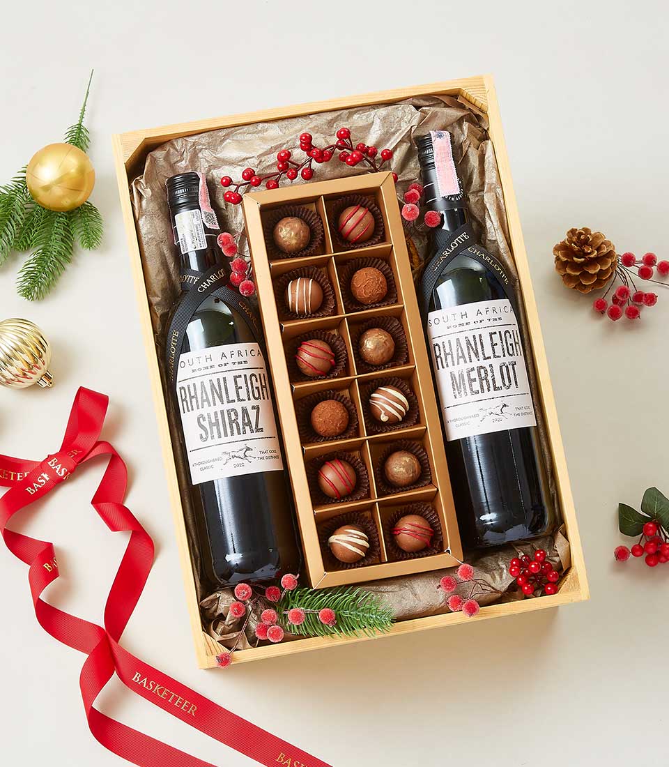 Elegant wine and chocolate gift hamper with two South African red wines, assorted chocolates, and festive woodland styling