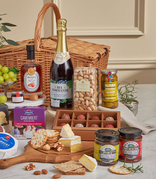 Luxury gourmet gift basket with sparkling wine, artisan cheeses, crackers, pistachios, jam, honey, and chocolates