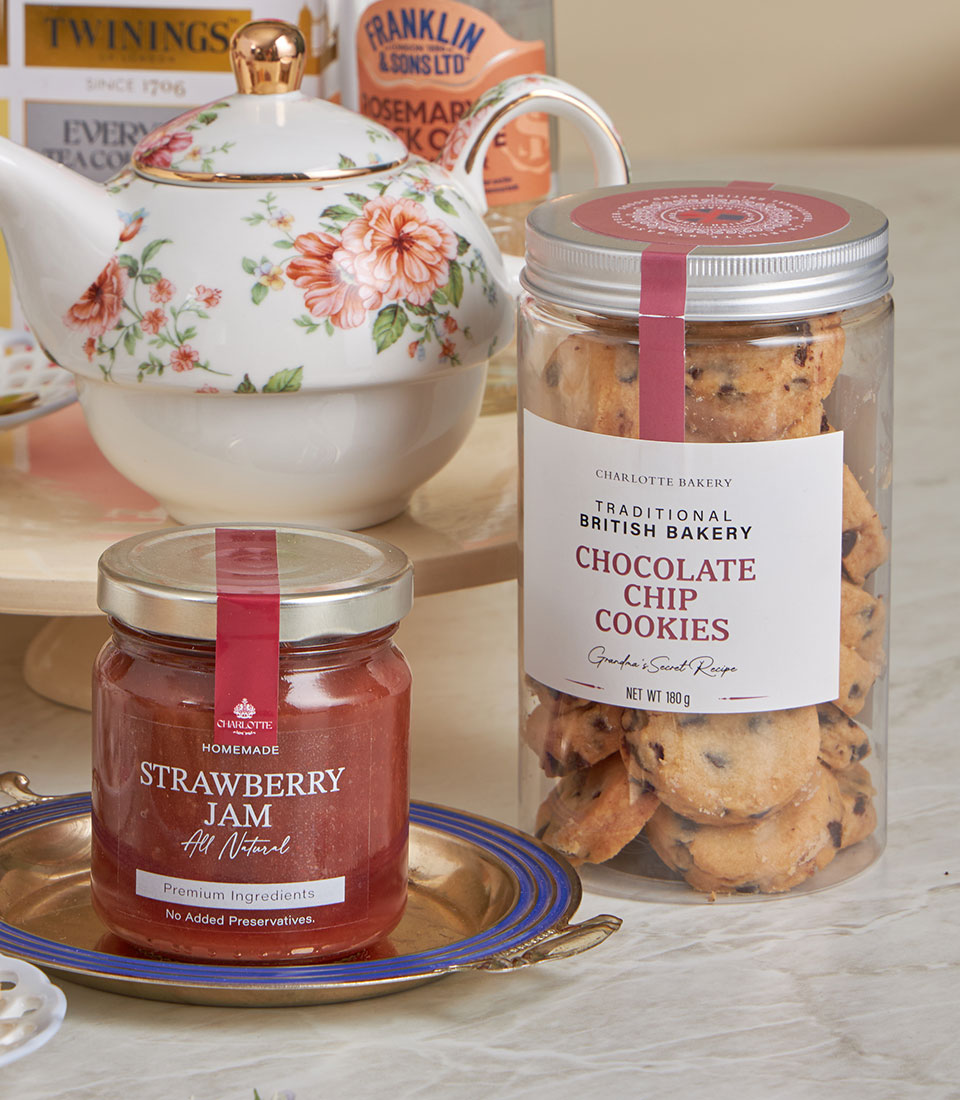 Deluxe teatime gift set with strawberry jam, chocolate chip cookies, and floral teapot for New Year celebrations