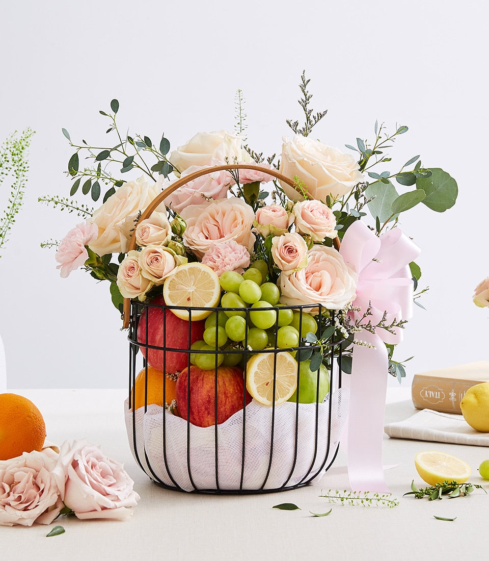 Fresh fruit basket with pink roses, apples, oranges, and grapes for birthday celebrations