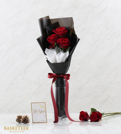 Flame of Love red roses bouquet with black and white wrapping in clear glass vase, gift card and pinecones