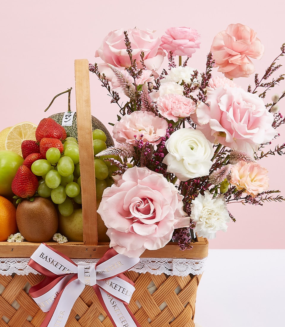 Mixed fruit and pink rose gift basket with strawberries, grapes, and fresh flowers for congratulations
