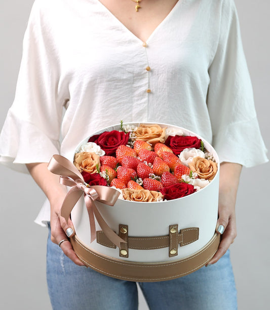 Premium round gift box filled with fresh red strawberries and roses, tied with satin ribbon