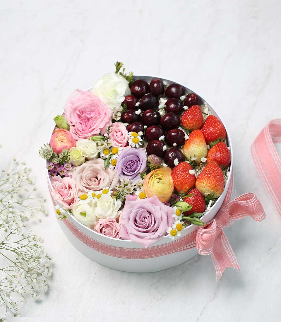 Premium mixed roses and fresh berries in round white gift box with pink striped ribbon