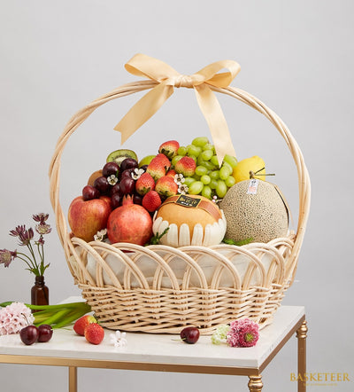 Basketeer premium hamper delivery Thailand: Wicker gift basket with melon, pomegranate, strawberries, grapes and a gold ribbon. Perfect corporate gift Bangkok.