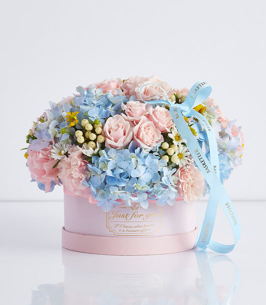 Soft pink and blue floral arrangement with roses and hydrangeas in luxury hatbox, Mother's Day gift